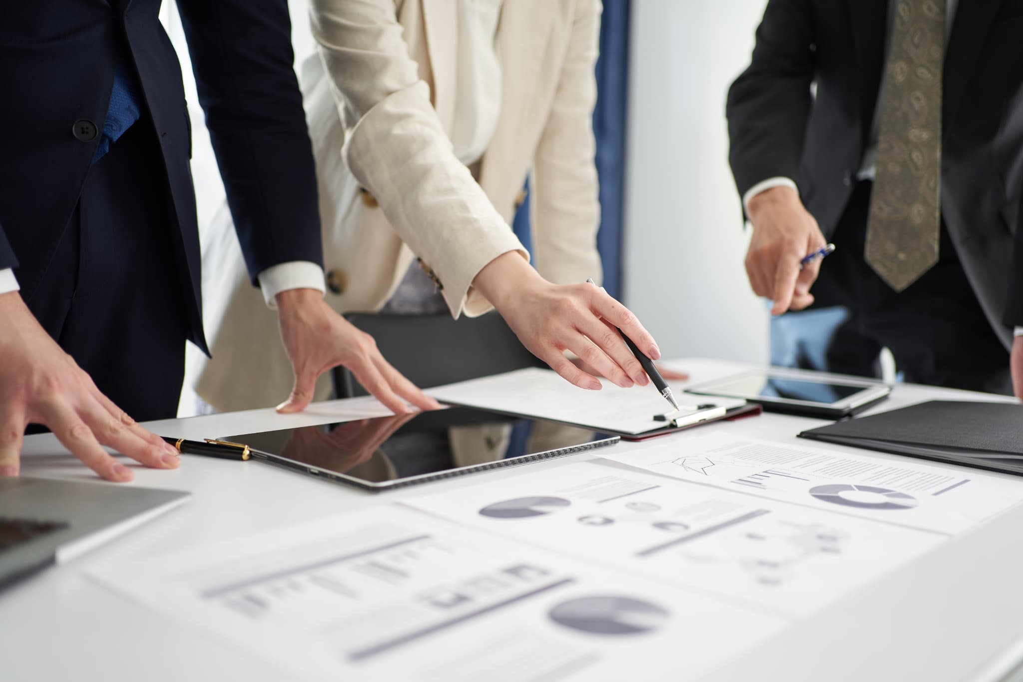 笑顔で写真に写る３人の会社員