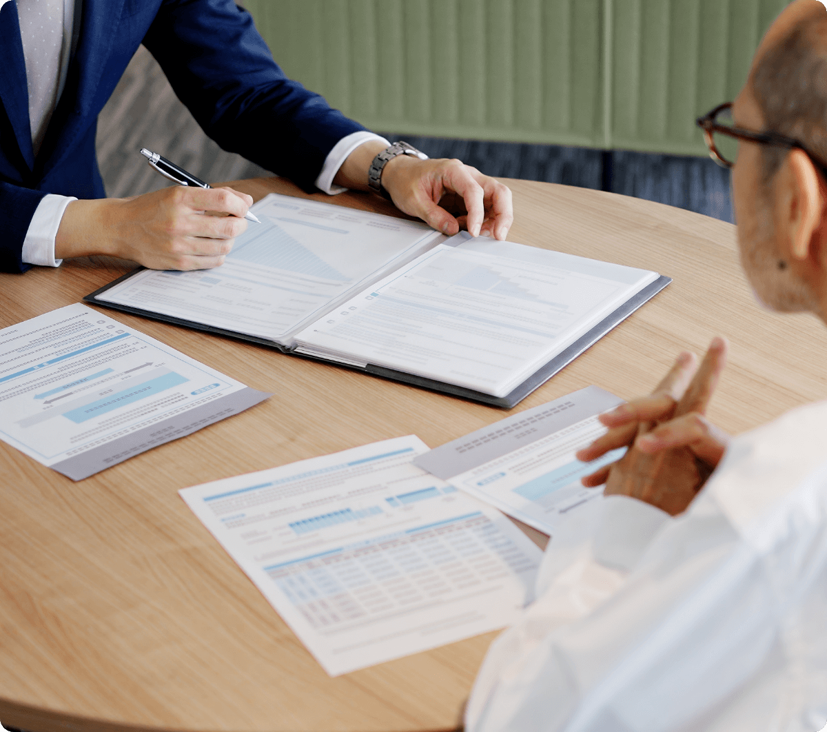 資料を用いて打ち合わせる会社員