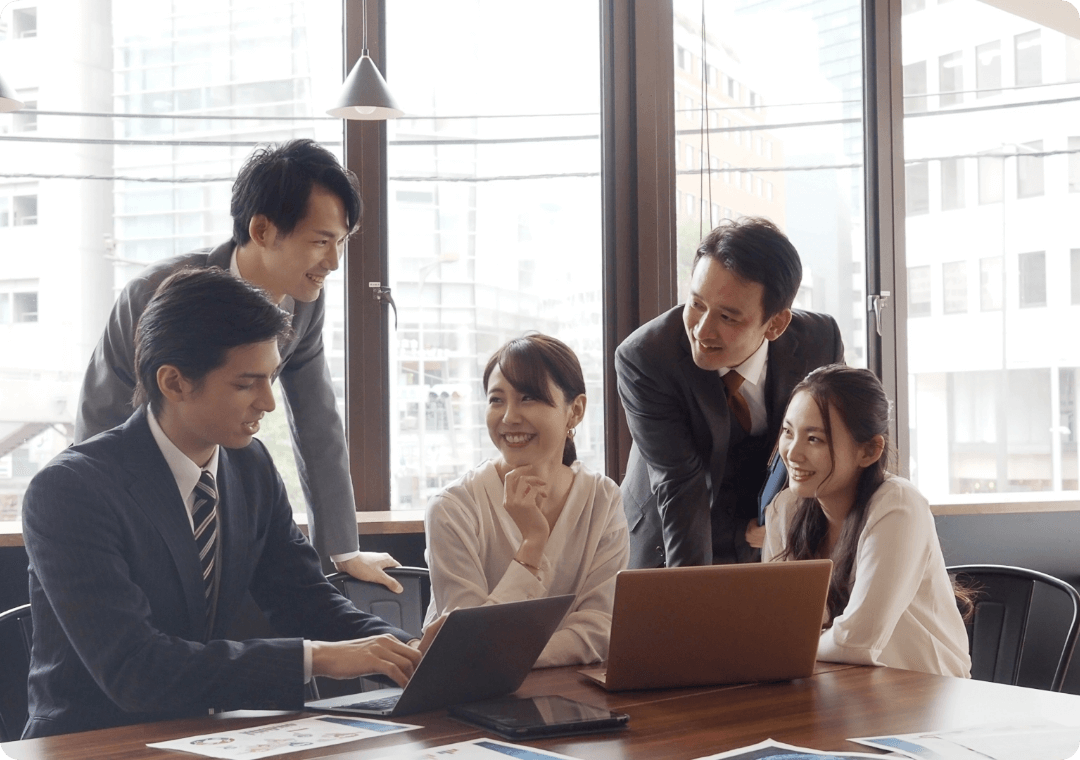 笑顔で打ち合わせをする５人の会社員